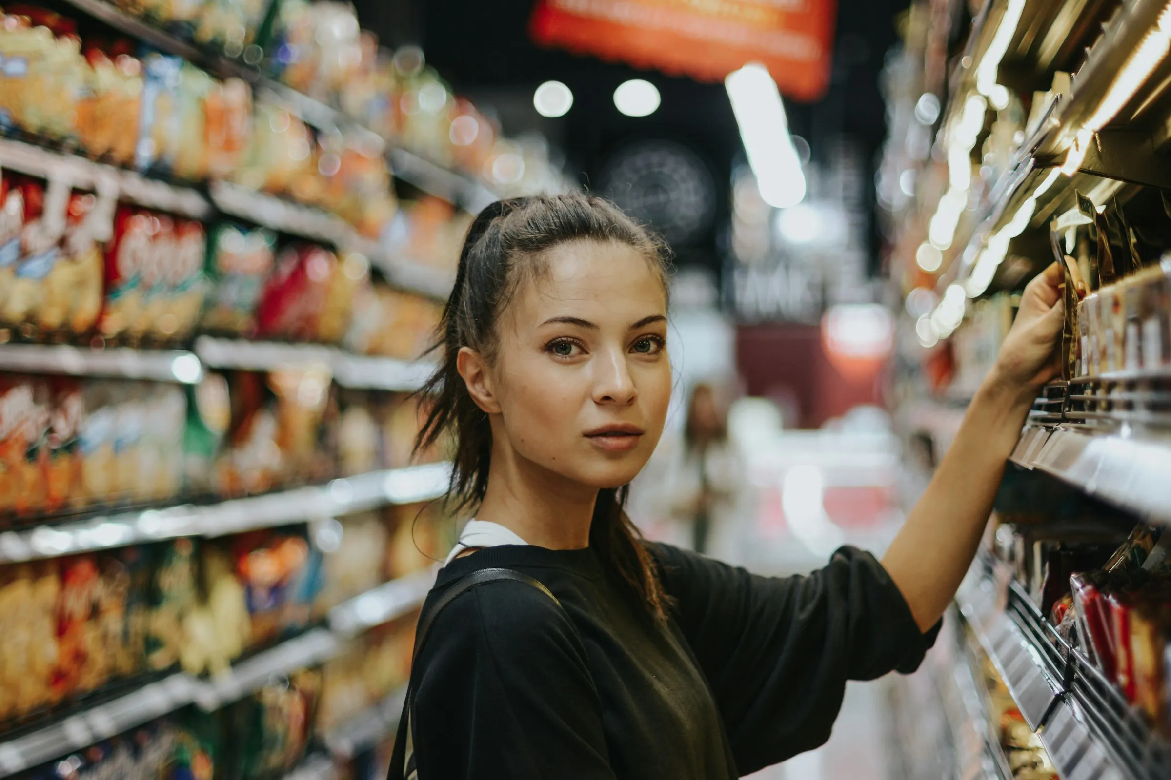 Shopper reaching for products on a store shelf